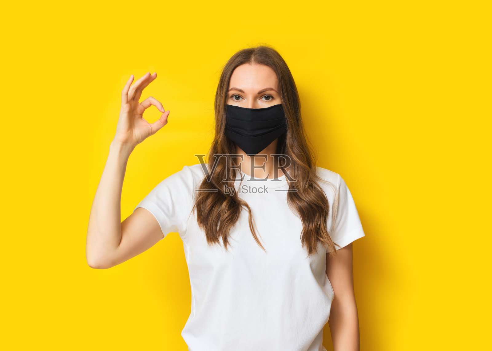 年轻的成年妇女肖像在医药面具在黄色的背景照片摄影图片