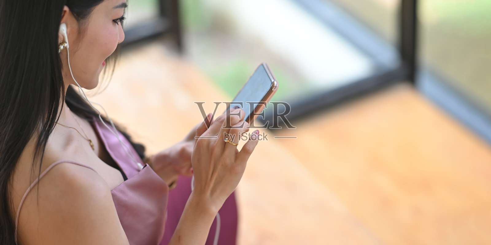 在客厅里用智能手机拍摄女性照片。照片摄影图片