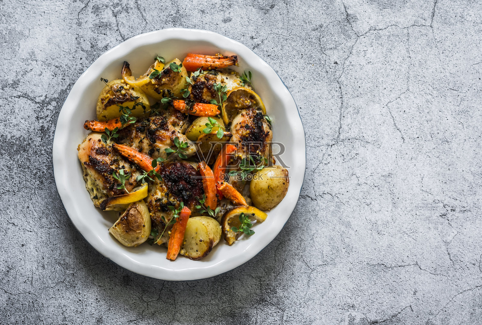 法式奶油烤鸡配土豆和胡萝卜，灰色背景，俯视图。美味的午餐照片摄影图片