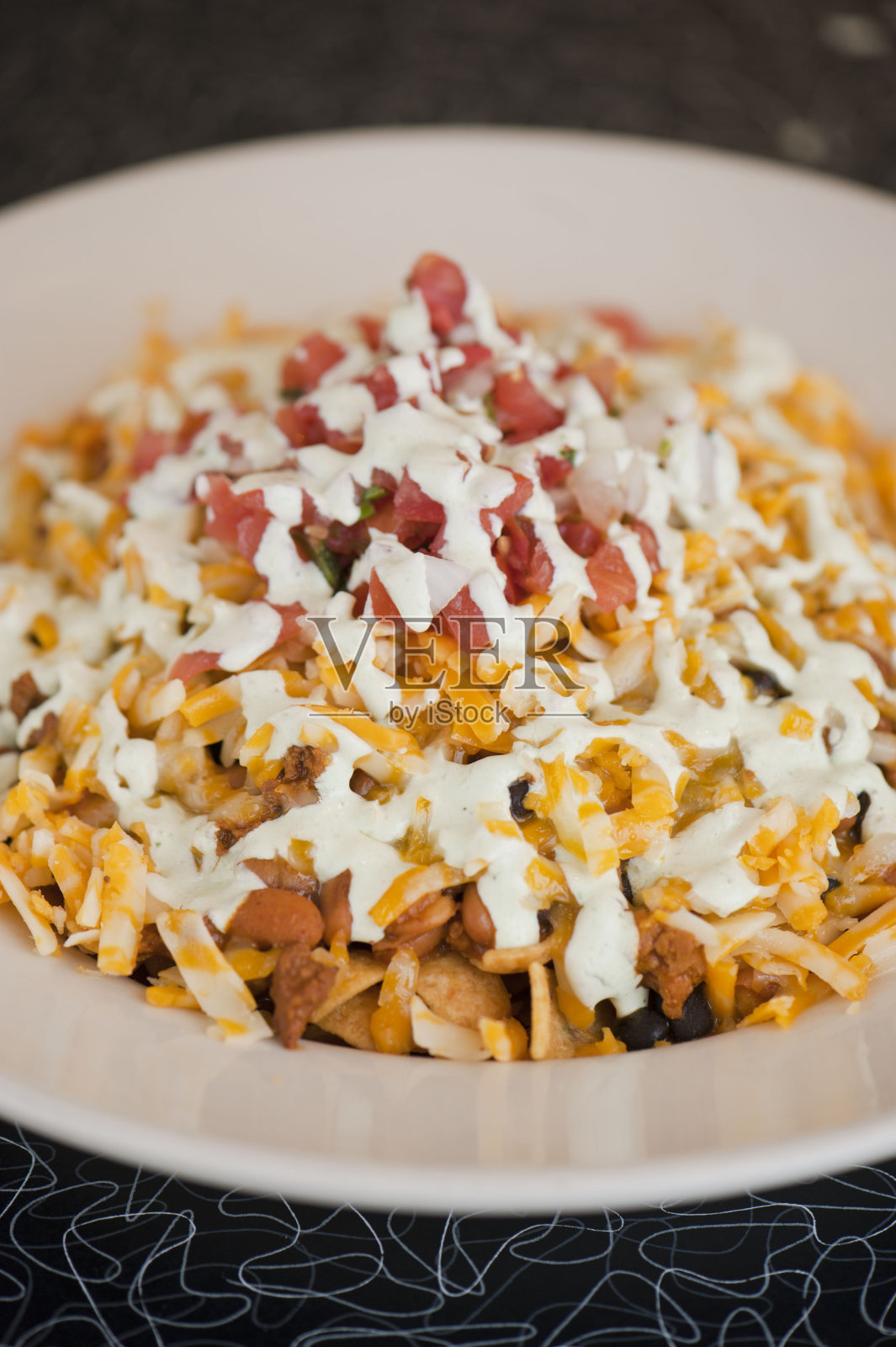 蓝玉米玉米片，调味鸡丝，切达奶酪，jalapeños，自制玉米玉米片和鳄梨酱。装在外带盒里的经典德州墨西哥街头小吃。照片摄影图片