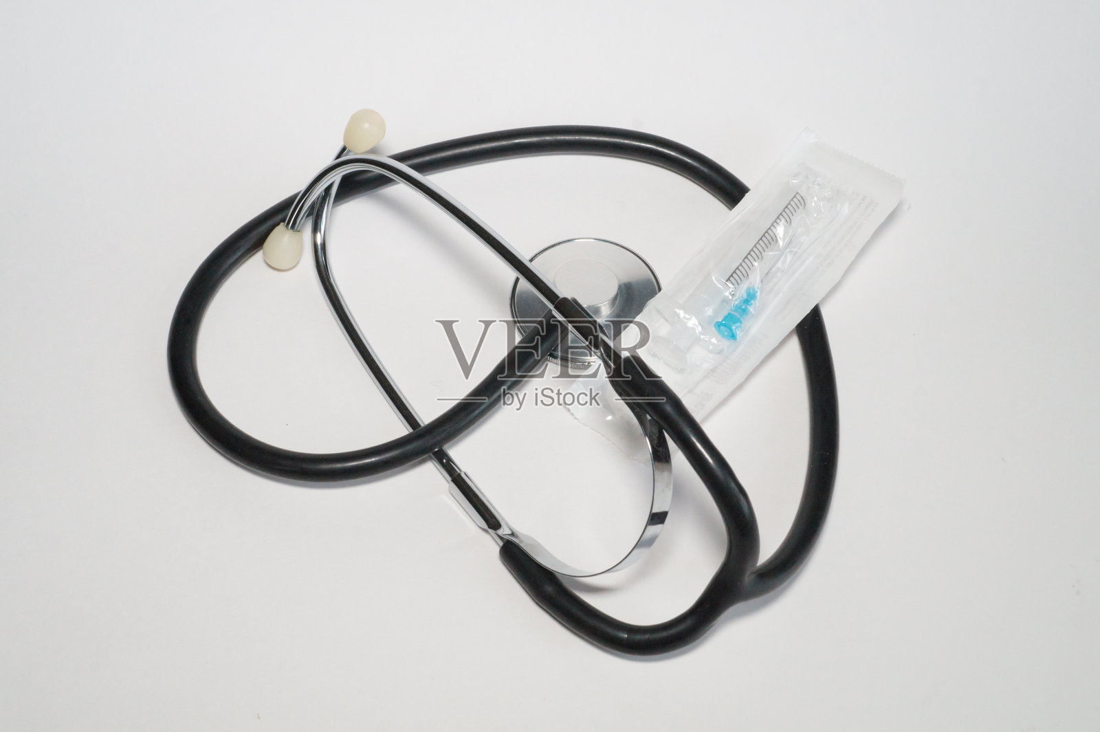 听诊器和一次性塑料注射器盖照片摄影图片