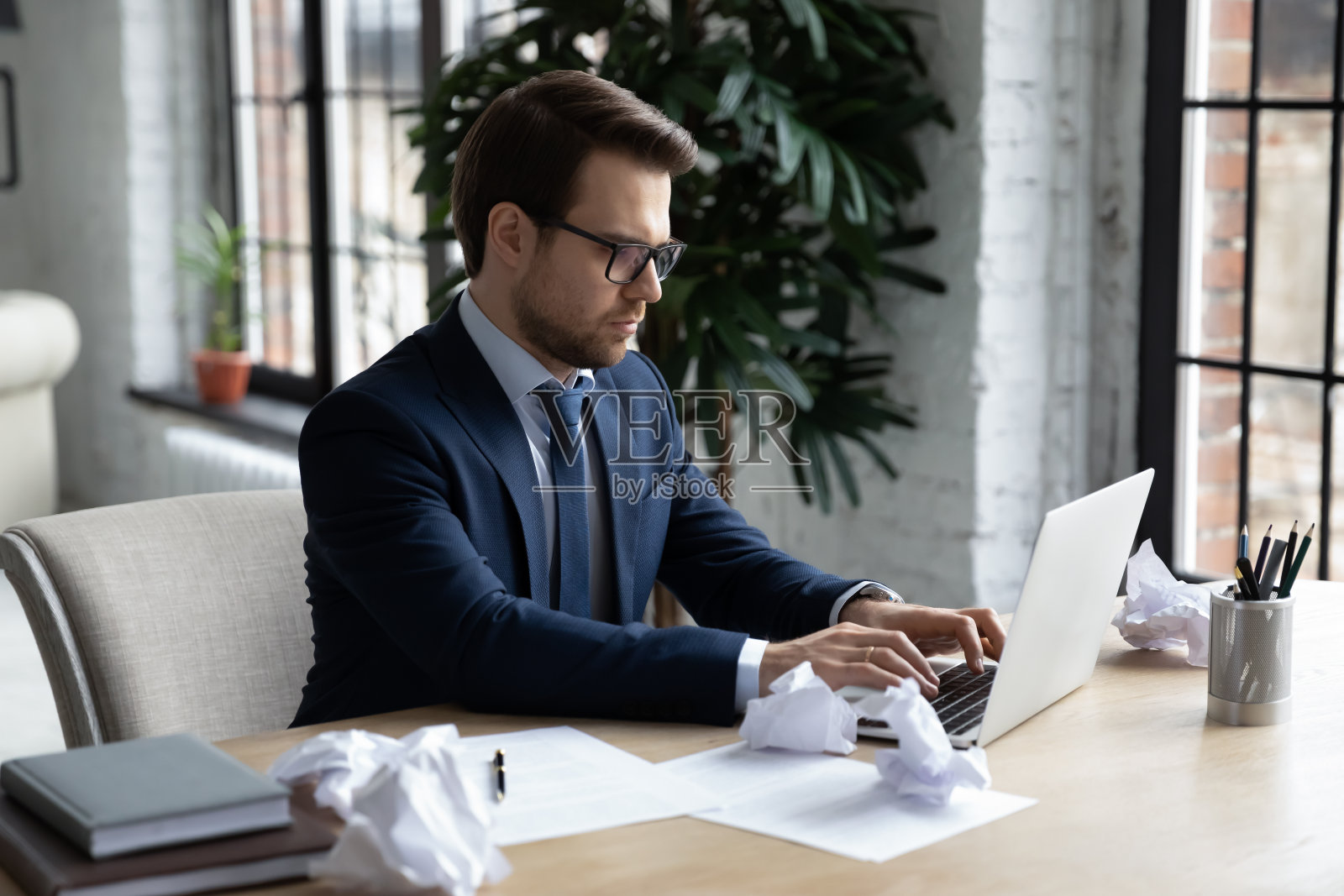 男员工在办公室忙着用笔记本电脑工作照片摄影图片