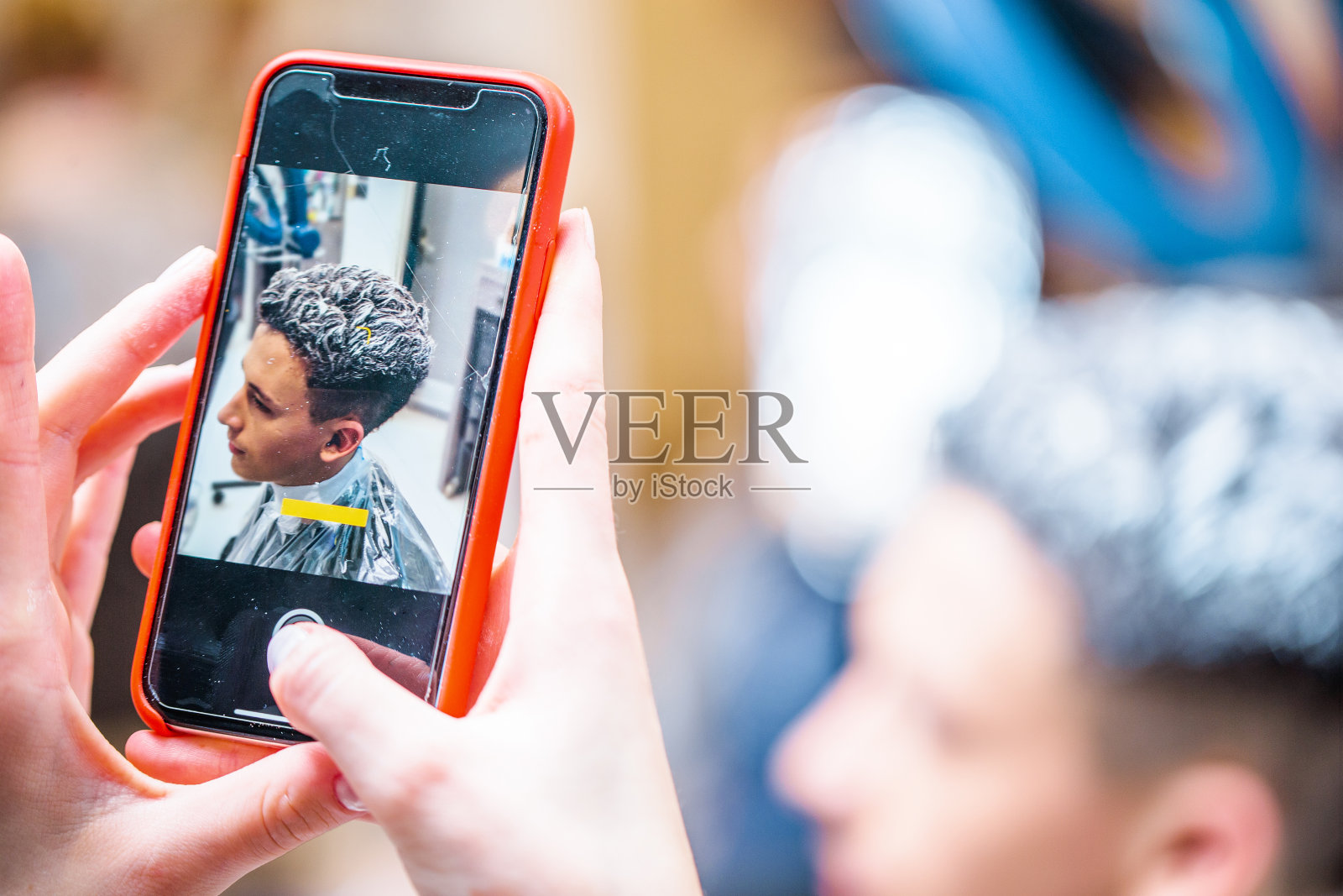 理发师用手机捕捉顾客的形象照片摄影图片