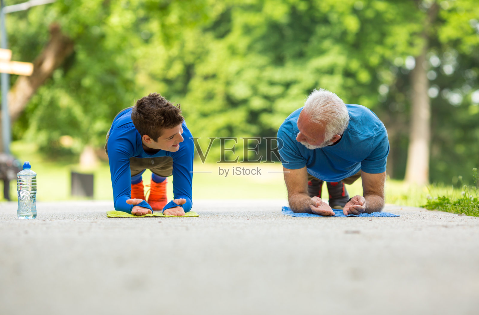 爷爷告诉他的孙子如何做一个好的俯卧撑照片摄影图片