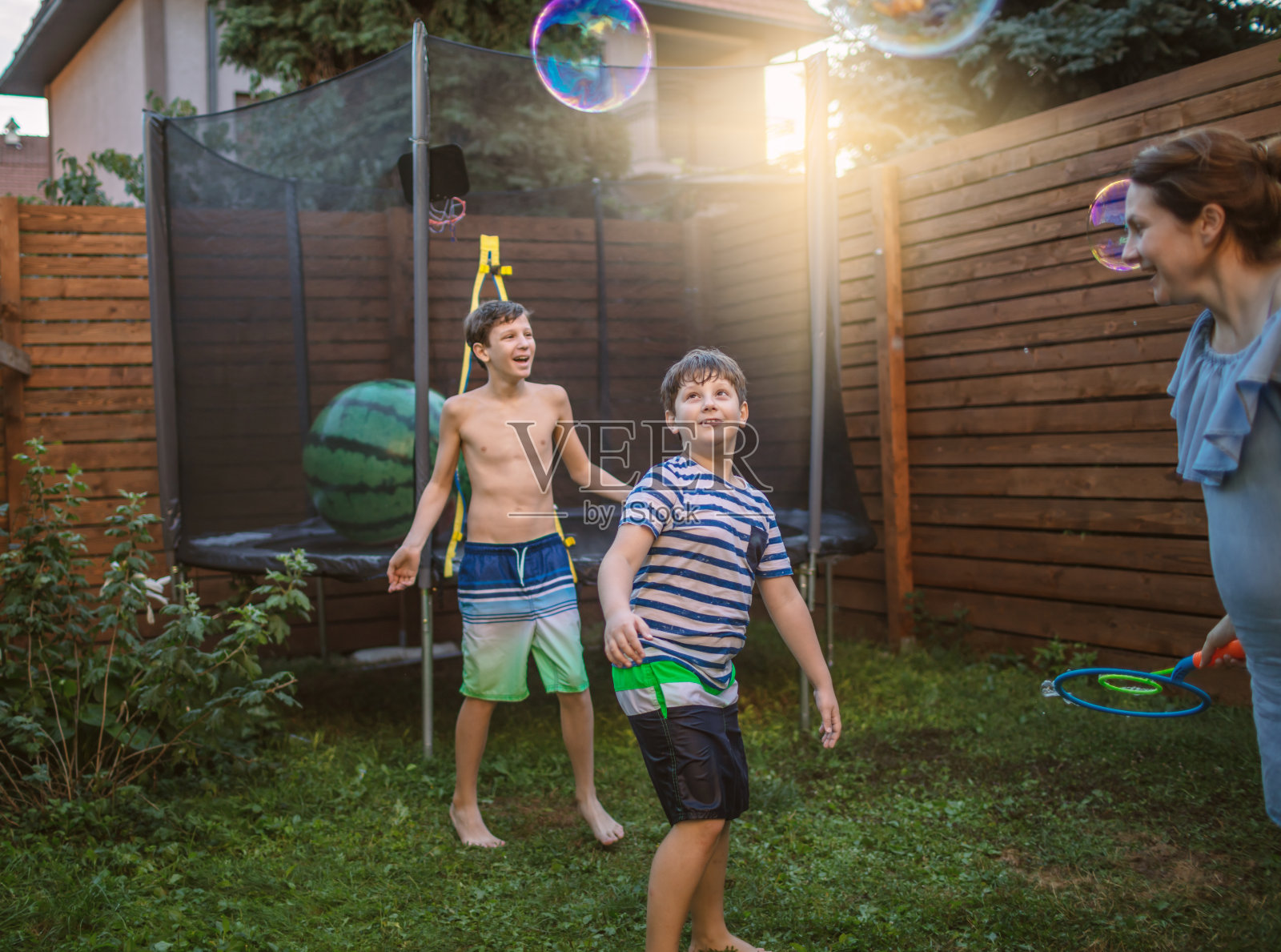 妈妈和男孩在院子里玩肥皂泡照片摄影图片