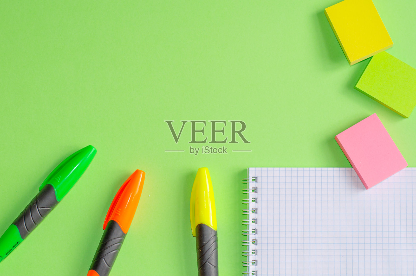 回到学校的概念。学校办公用品放在办公桌上，绿色为背景。平铺与拷贝空间。照片摄影图片