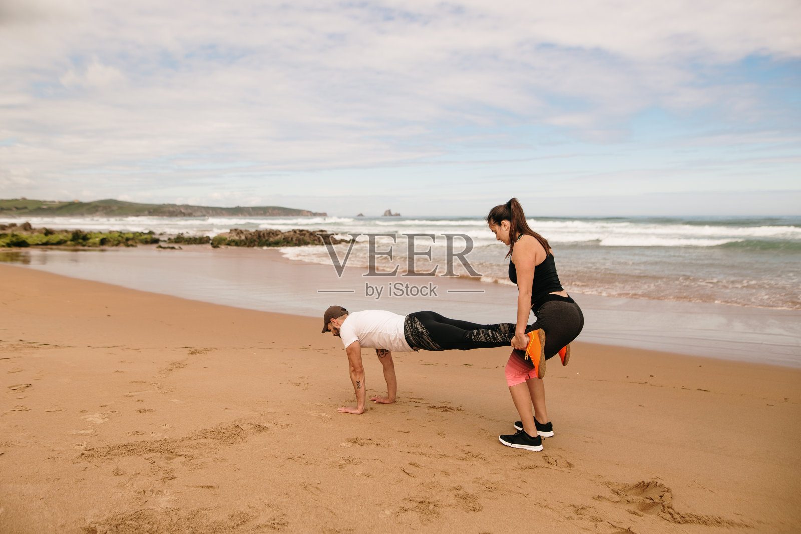一对年轻夫妇在海滩上一起锻炼照片摄影图片