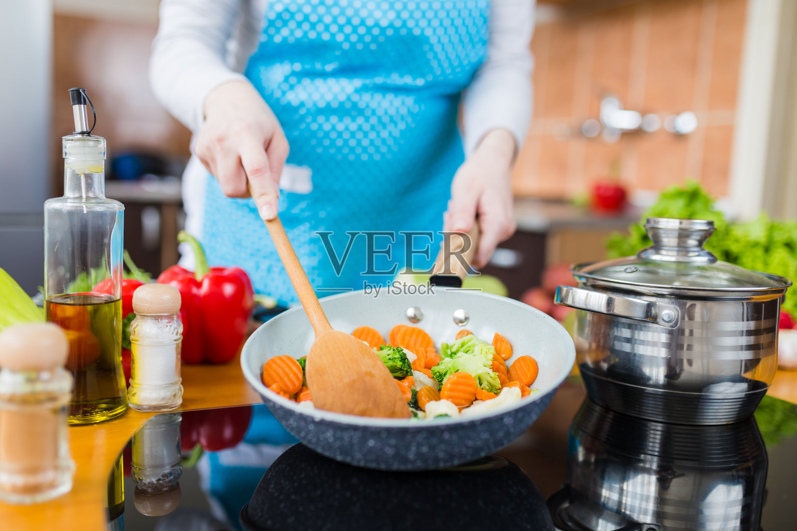 女人拿着装满混合蔬菜的锅的特写。健康的自制膳食准备概念。照片摄影图片