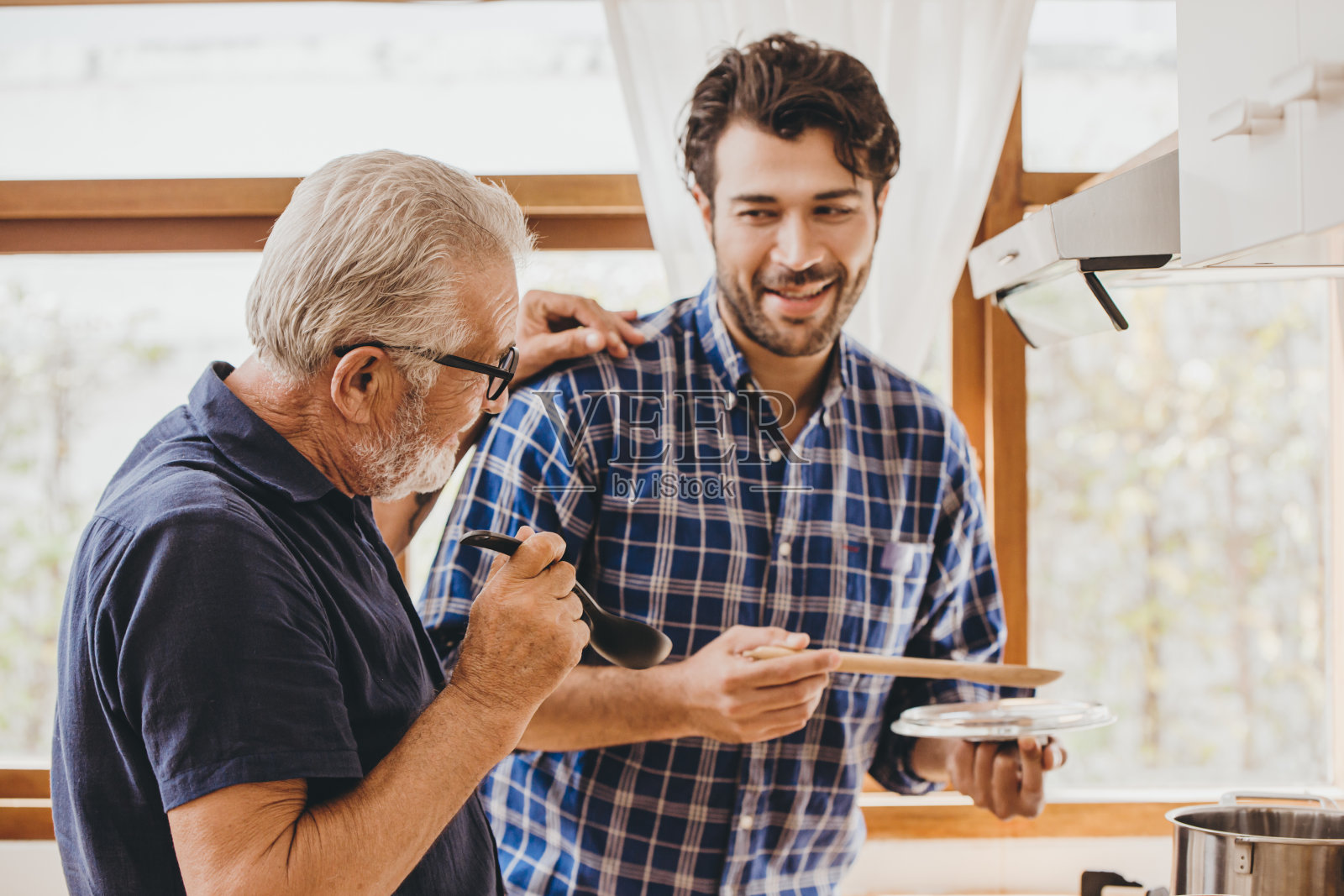 快乐的老人喜欢与家人在厨房做饭，居家休闲活动和人们的生活方式。照片摄影图片