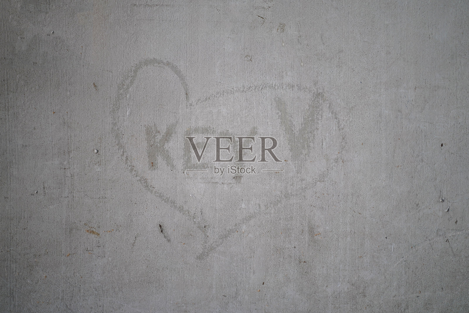 在旧水泥墙上刻心标志的关键词。照片摄影图片