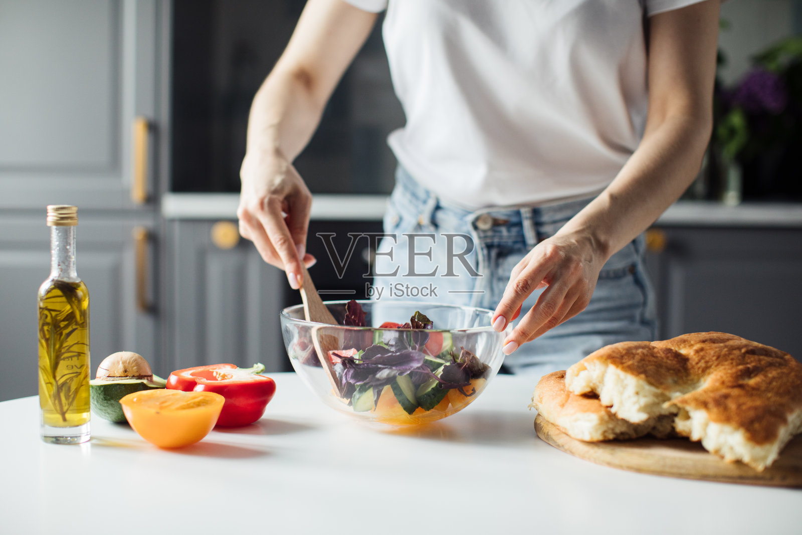 一个女孩切蔬菜做沙拉的手的特写。健康的食物照片摄影图片