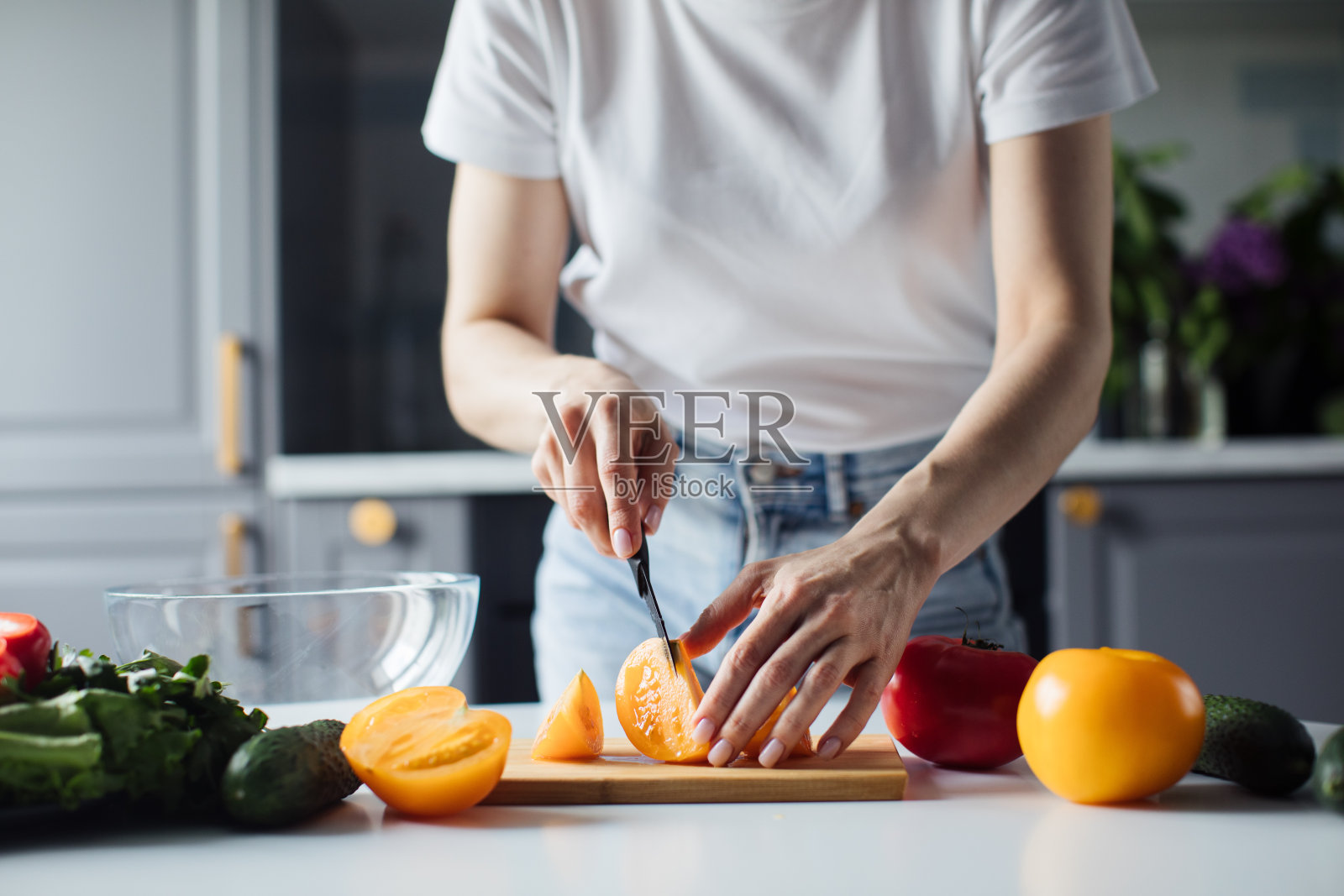 一个女孩切蔬菜做沙拉的手的特写。健康的食物照片摄影图片
