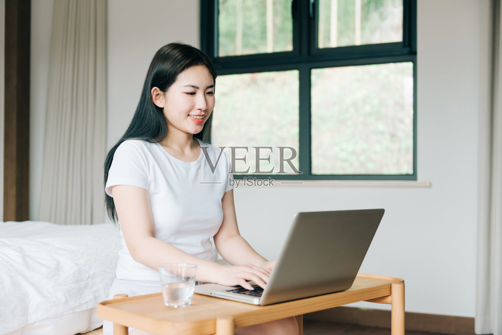 年轻的亚洲女孩在床上使用笔记本电脑照片摄影图片