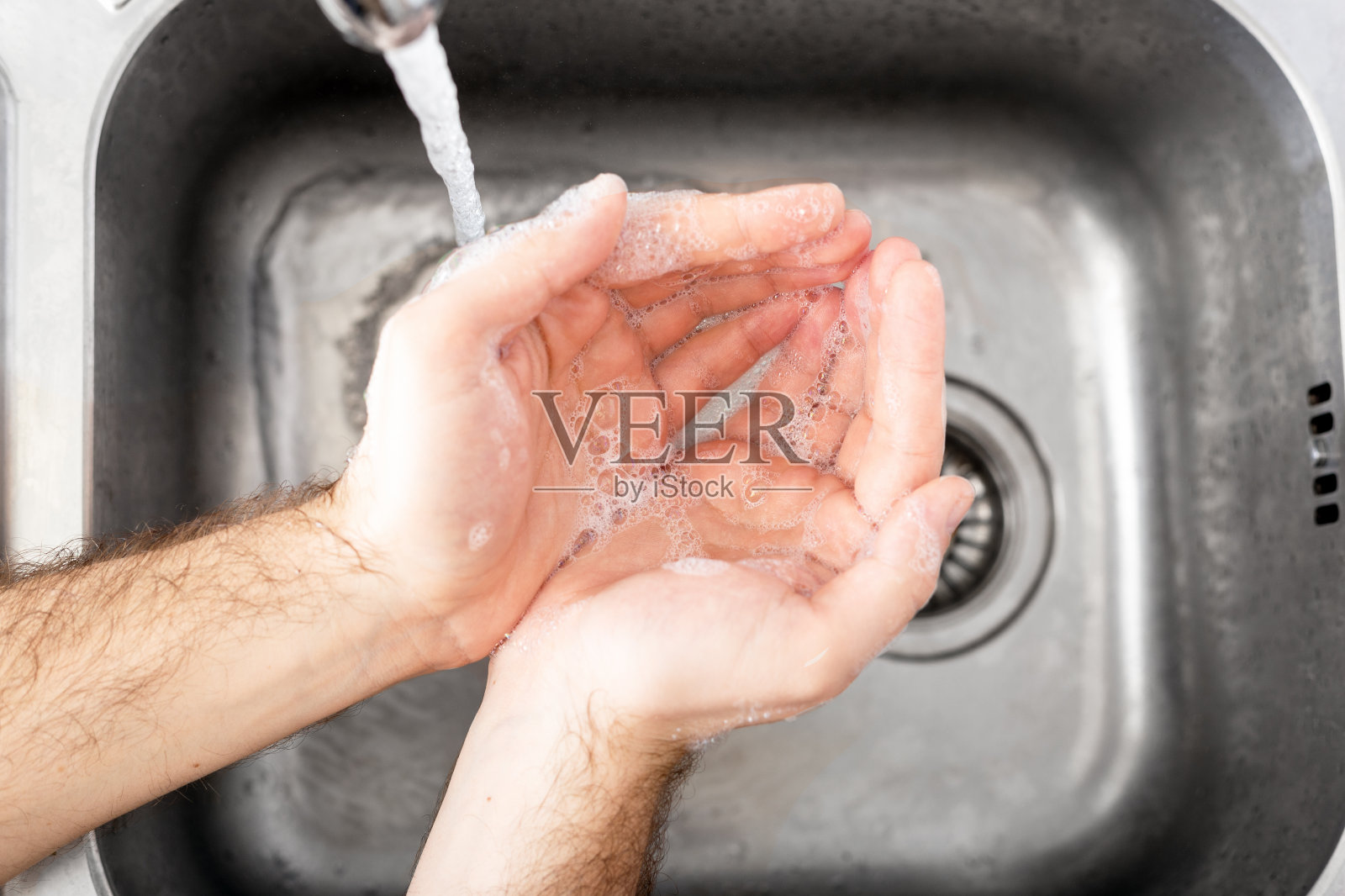 男士在金属水槽内用抗菌肥皂和水洗手，以预防冠状病毒。手卫生、保健、医疗理念。手部皮肤消毒预防冠状病毒19照片摄影图片