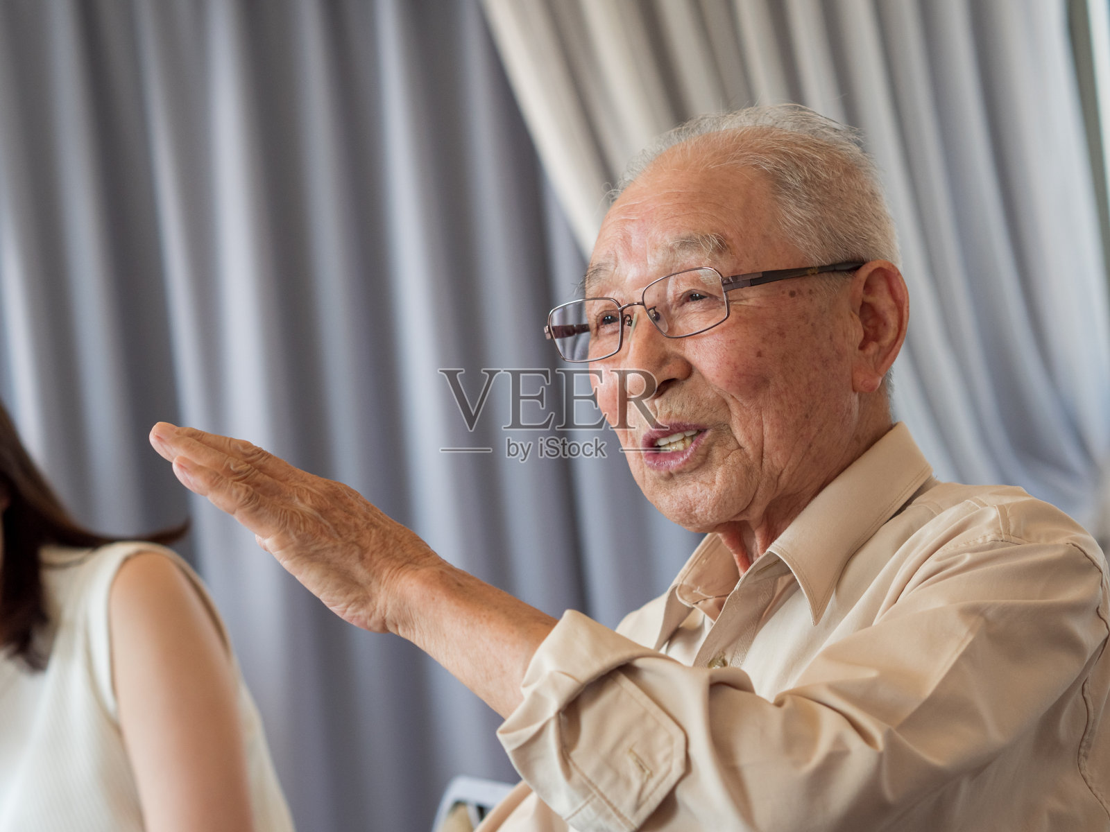 一位老人在一次家庭聚会上兴致勃勃地谈论着照片摄影图片