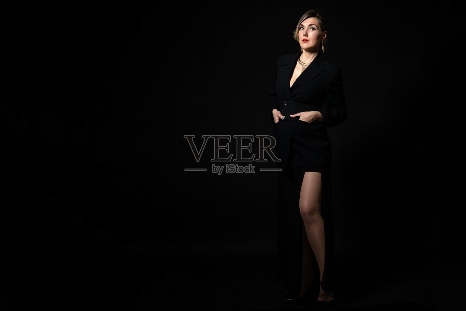 年轻自信的女孩在黑色背景的黑色商务套装，工作室时装照片与拷贝空间照片摄影图片