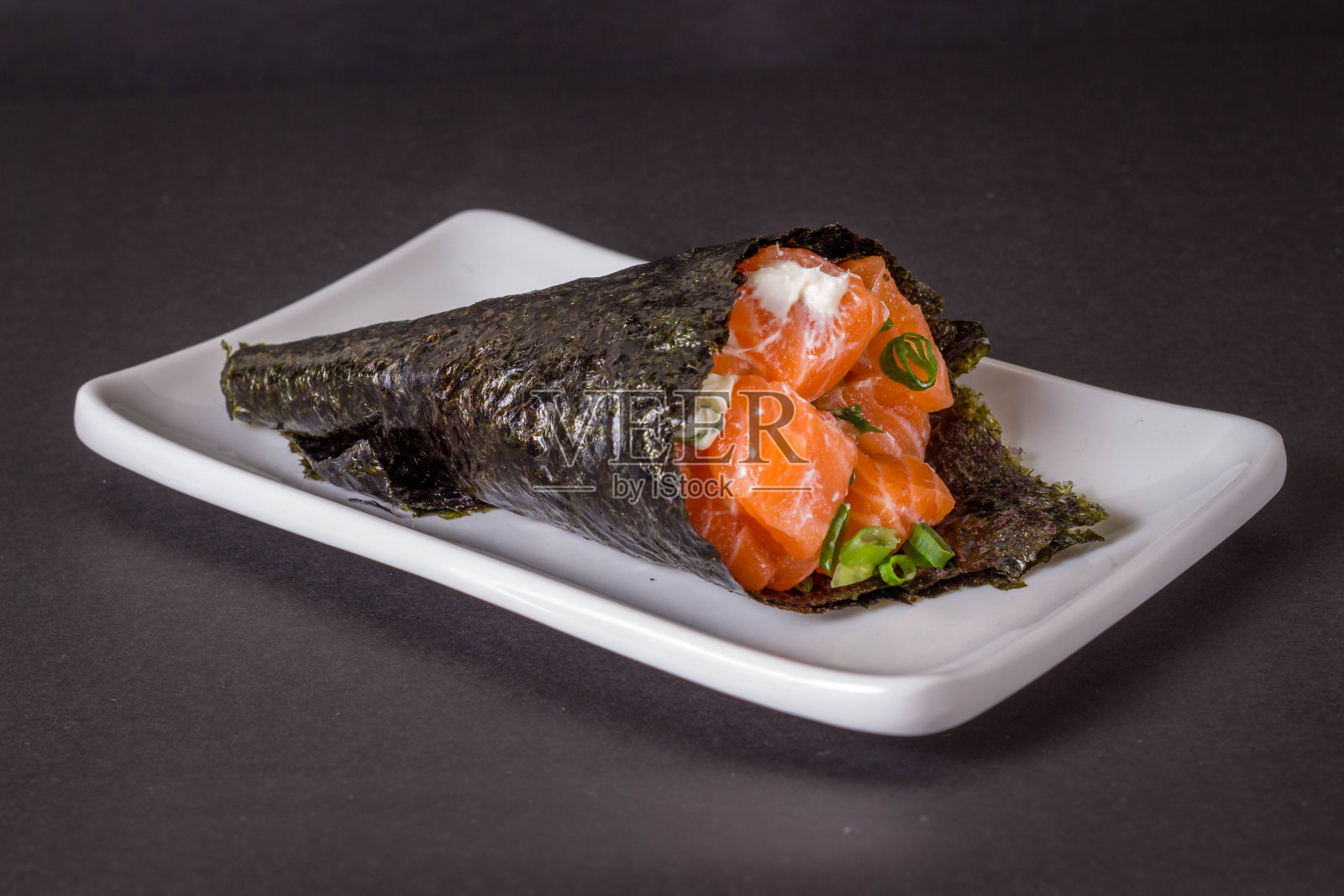 黑色背景的白盘子上的三文鱼寿司照片摄影图片