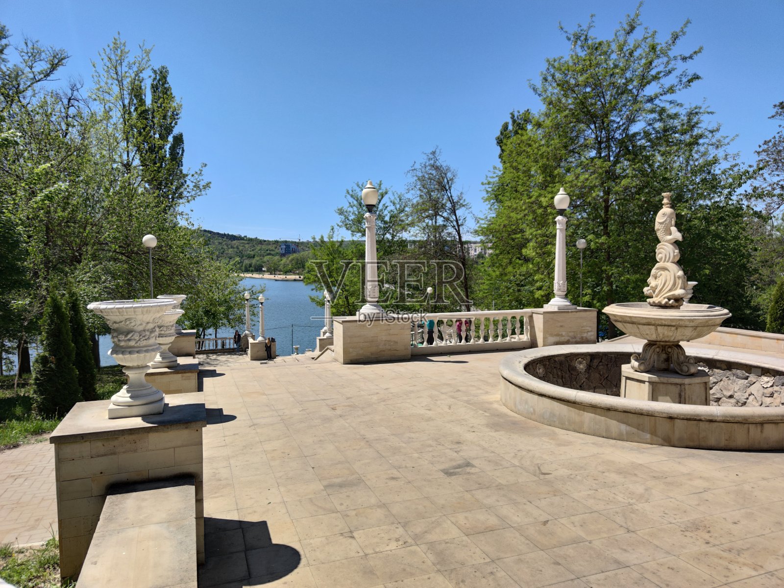 这个平台是用白石做的。栏杆上。蓝色的湖照片摄影图片