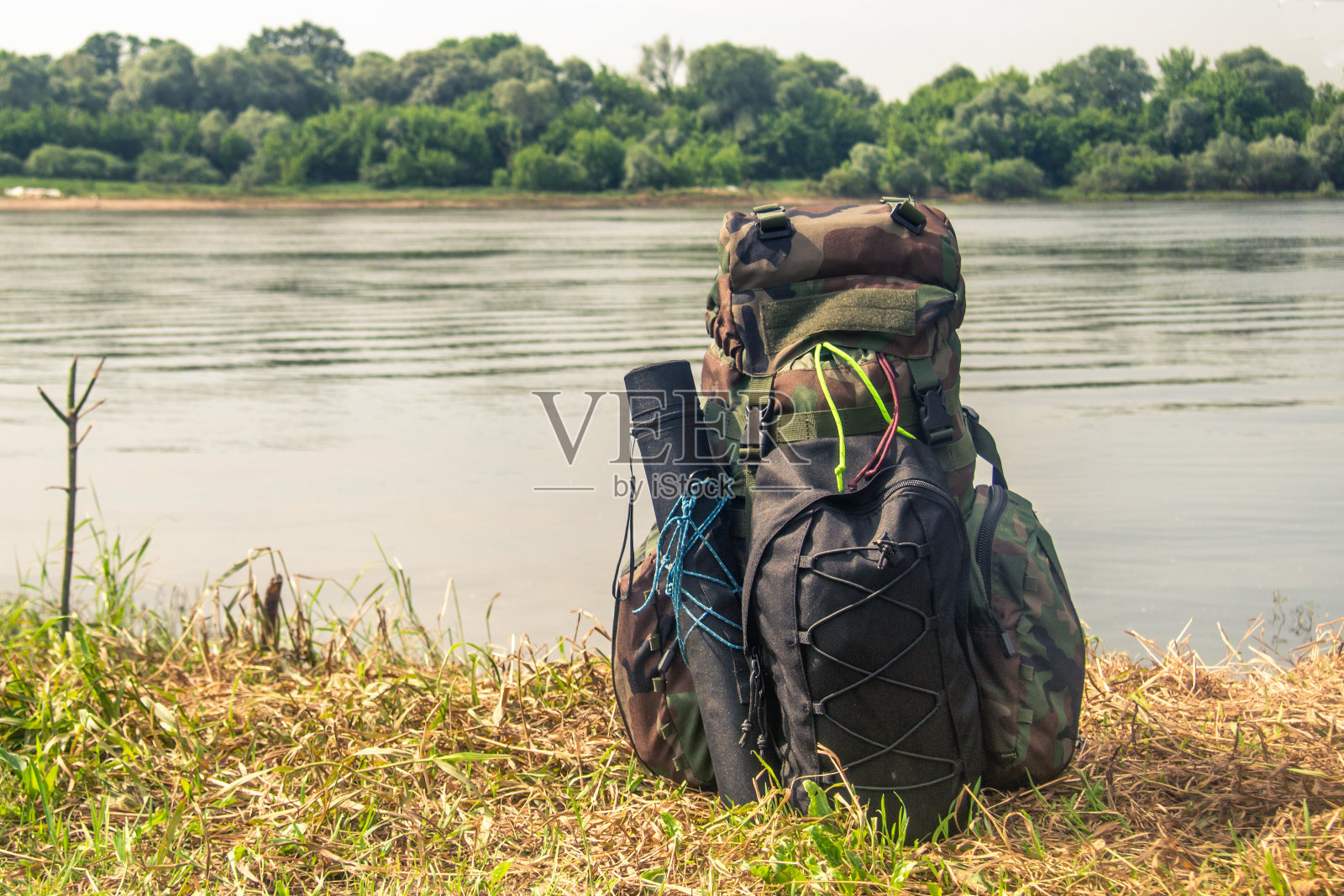 绿色迷彩战术军用背包站在河岸上照片摄影图片