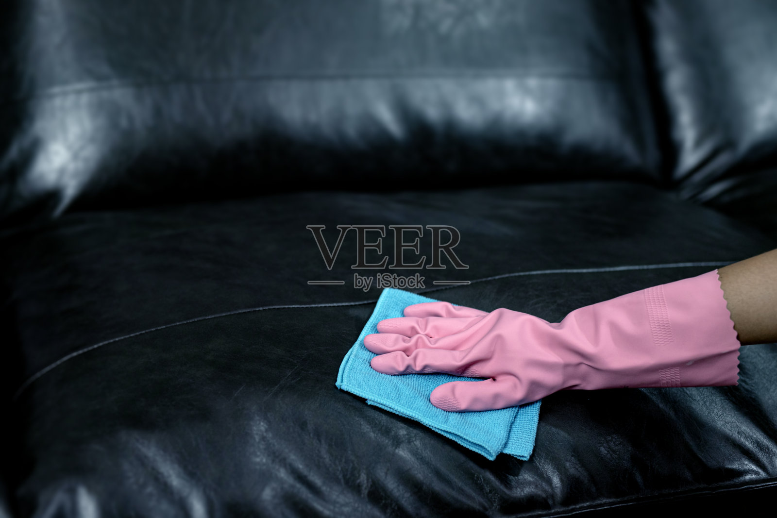 女人用杀菌喷雾擦沙发，再用毛巾擦。照片摄影图片