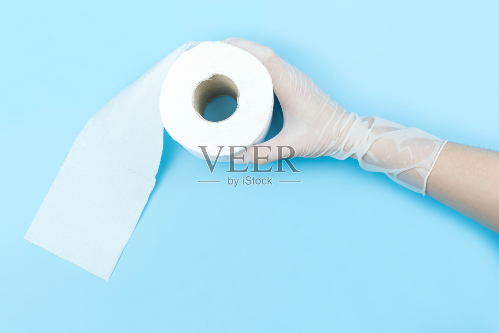 手在白色乳胶医疗手套拿卫生纸在蓝色背景和拷贝空间照片摄影图片