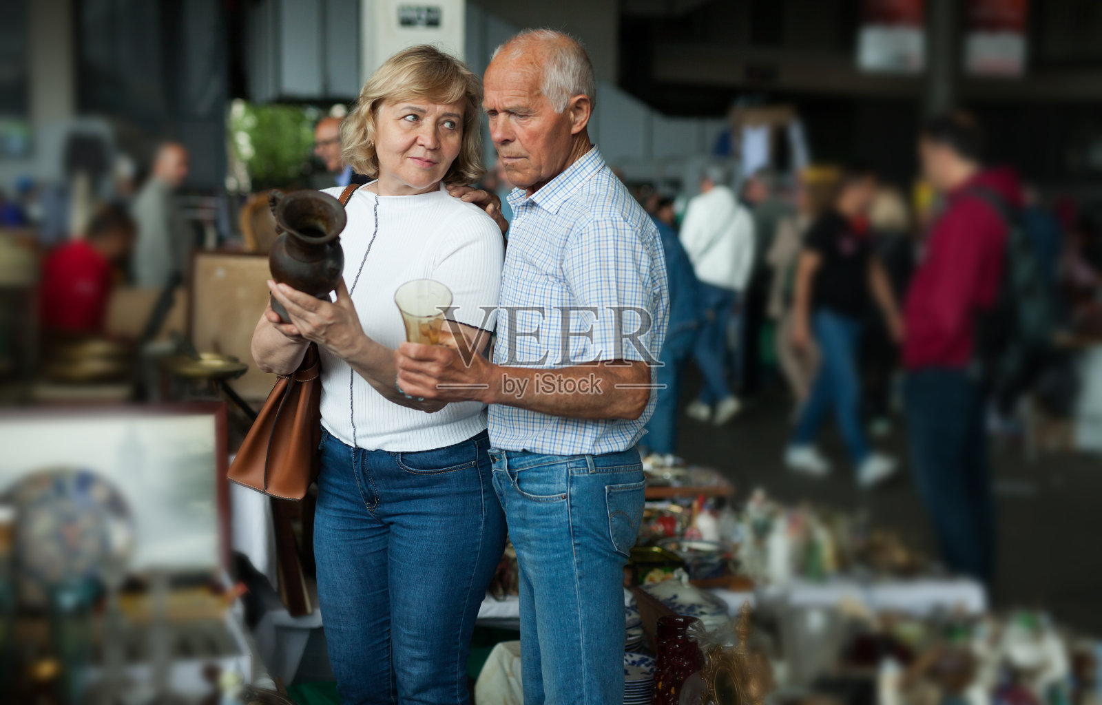 微笑的成熟配偶在跳蚤市场购买复古手工艺品照片摄影图片