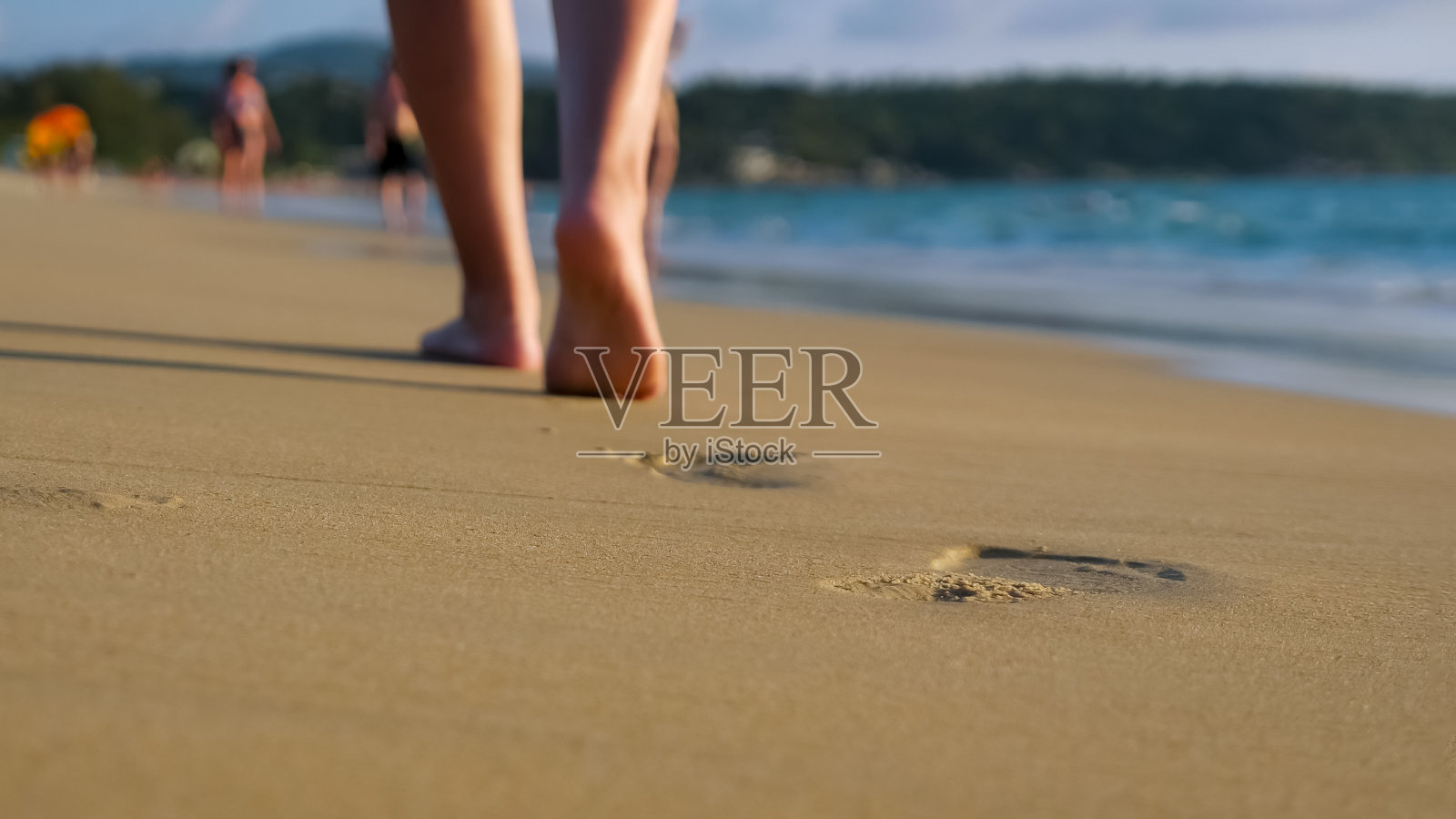 赤脚女士走在空旷的海洋海滩下的蓝天照片摄影图片