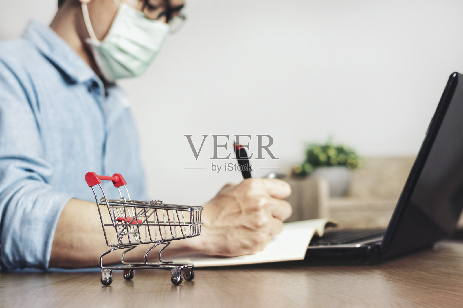 戴着口罩以防止新型冠状病毒的亚洲小企业主在家办公照片摄影图片