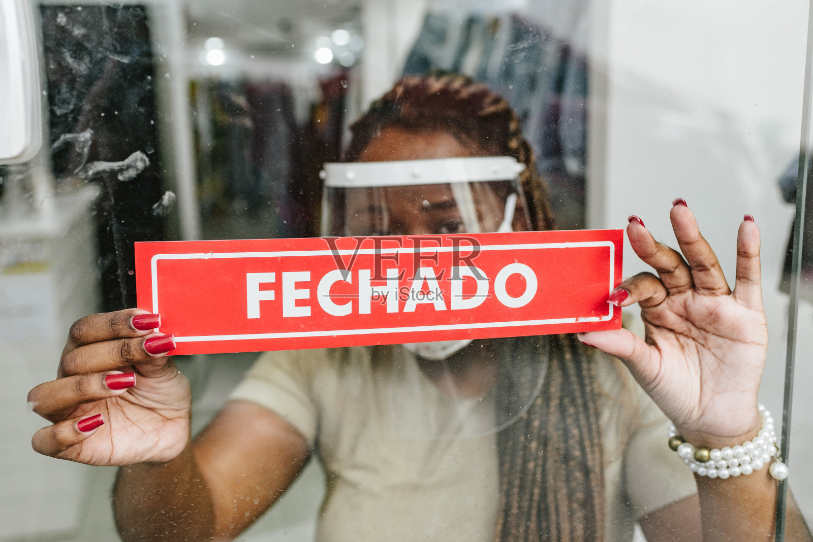 新冠肺炎:非洲妇女在商店悬挂关闭通知照片摄影图片