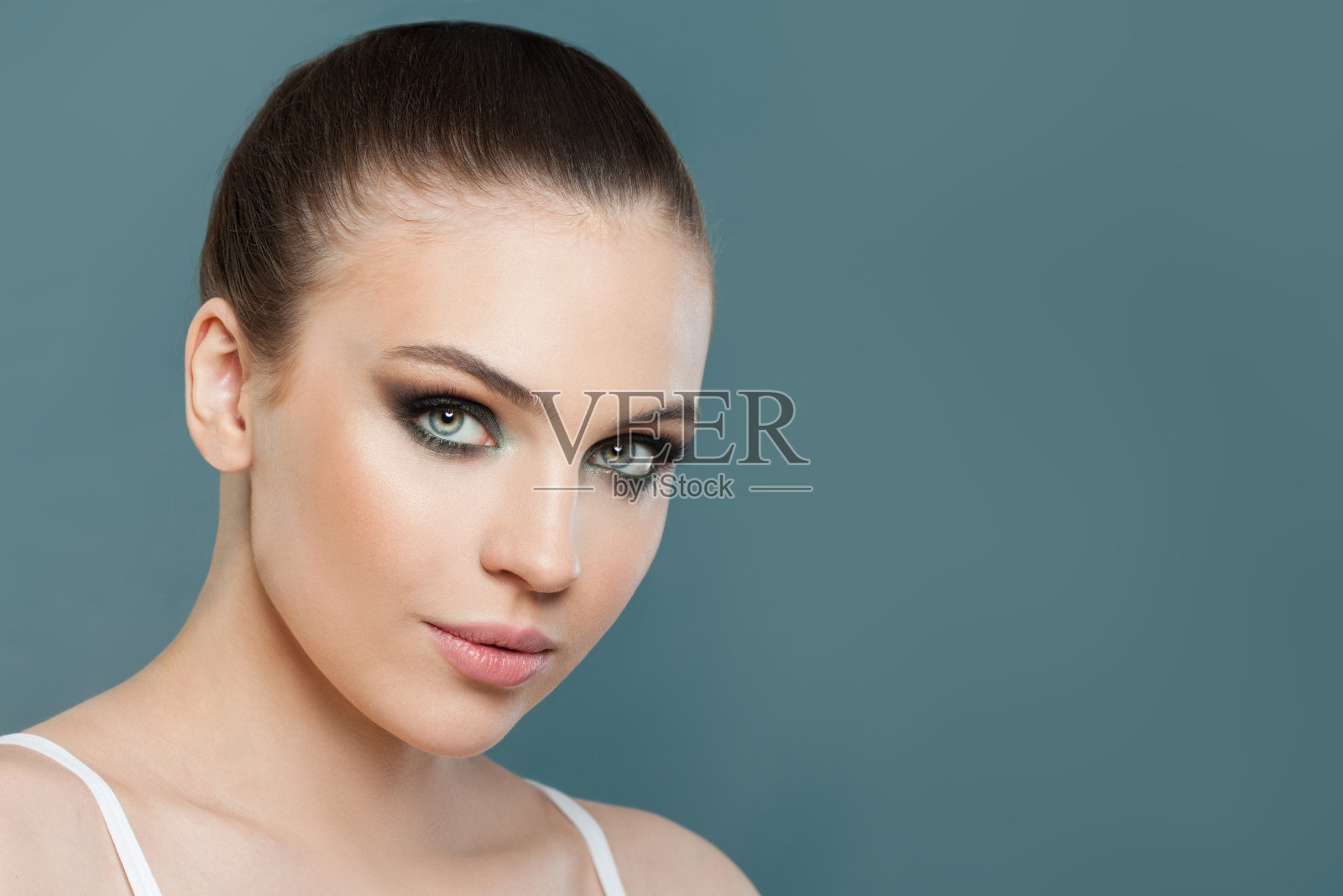 年轻可爱的模特与干净健康的皮肤在蓝色的背景照片摄影图片