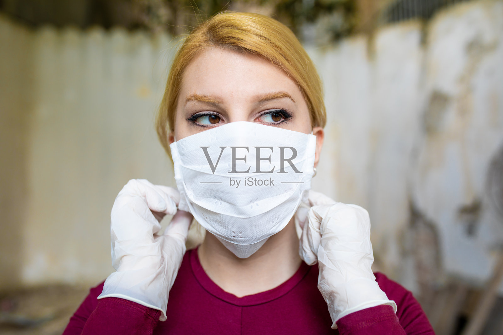 年轻女子把面具戴在脸上。照片摄影图片