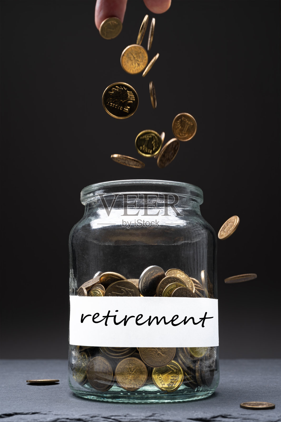 罐子里的硬币，标签上写着退休的字样。照片摄影图片