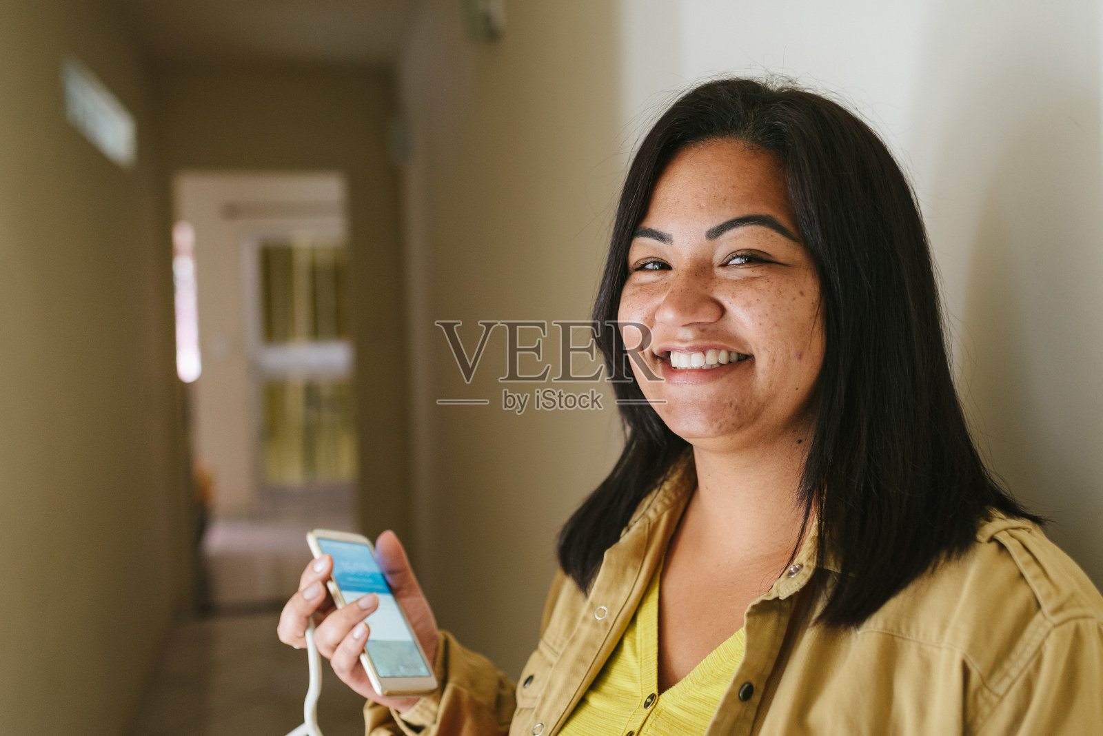 微笑的拉丁女人拿着智能手机照片摄影图片