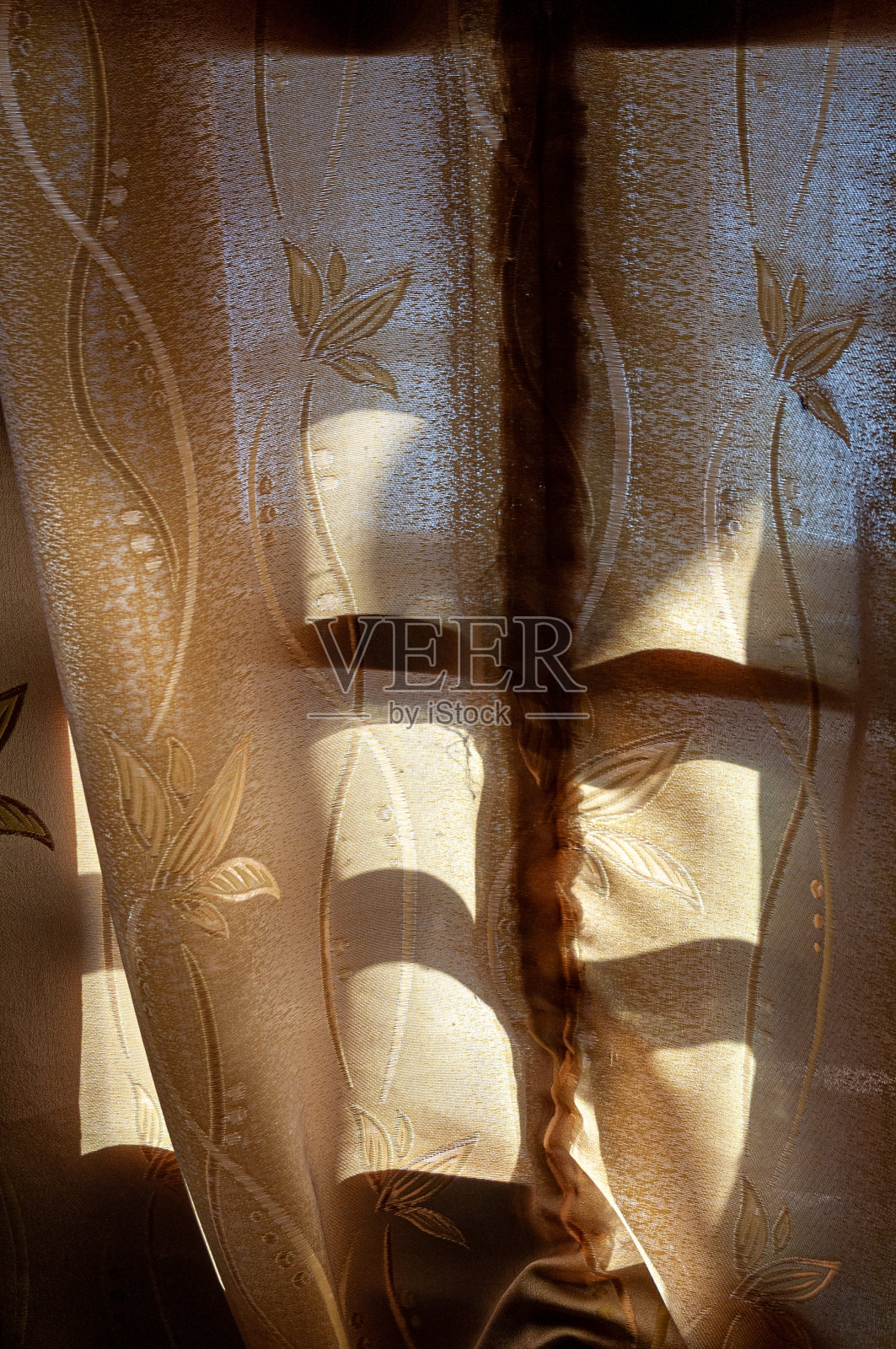 有窗帘围起来的窗户，阳光从窗帘中照射进来照片摄影图片