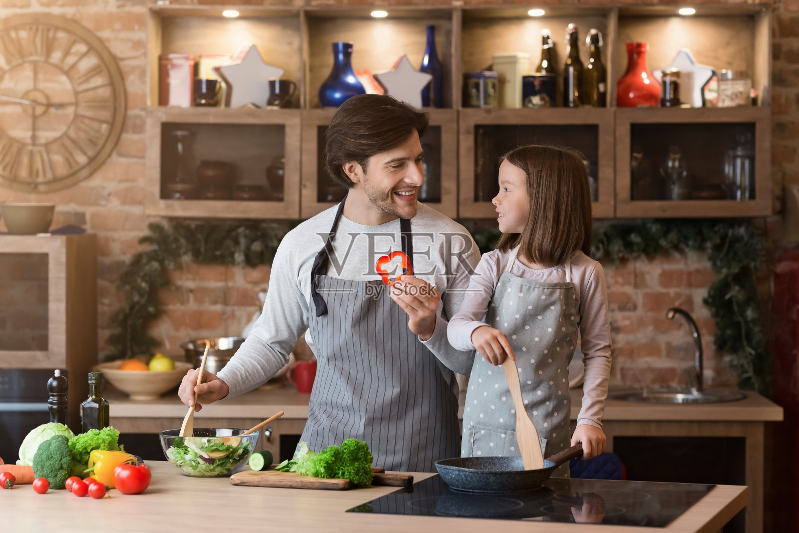 快乐的年轻爸爸和他的小女儿在厨房准备午餐照片摄影图片