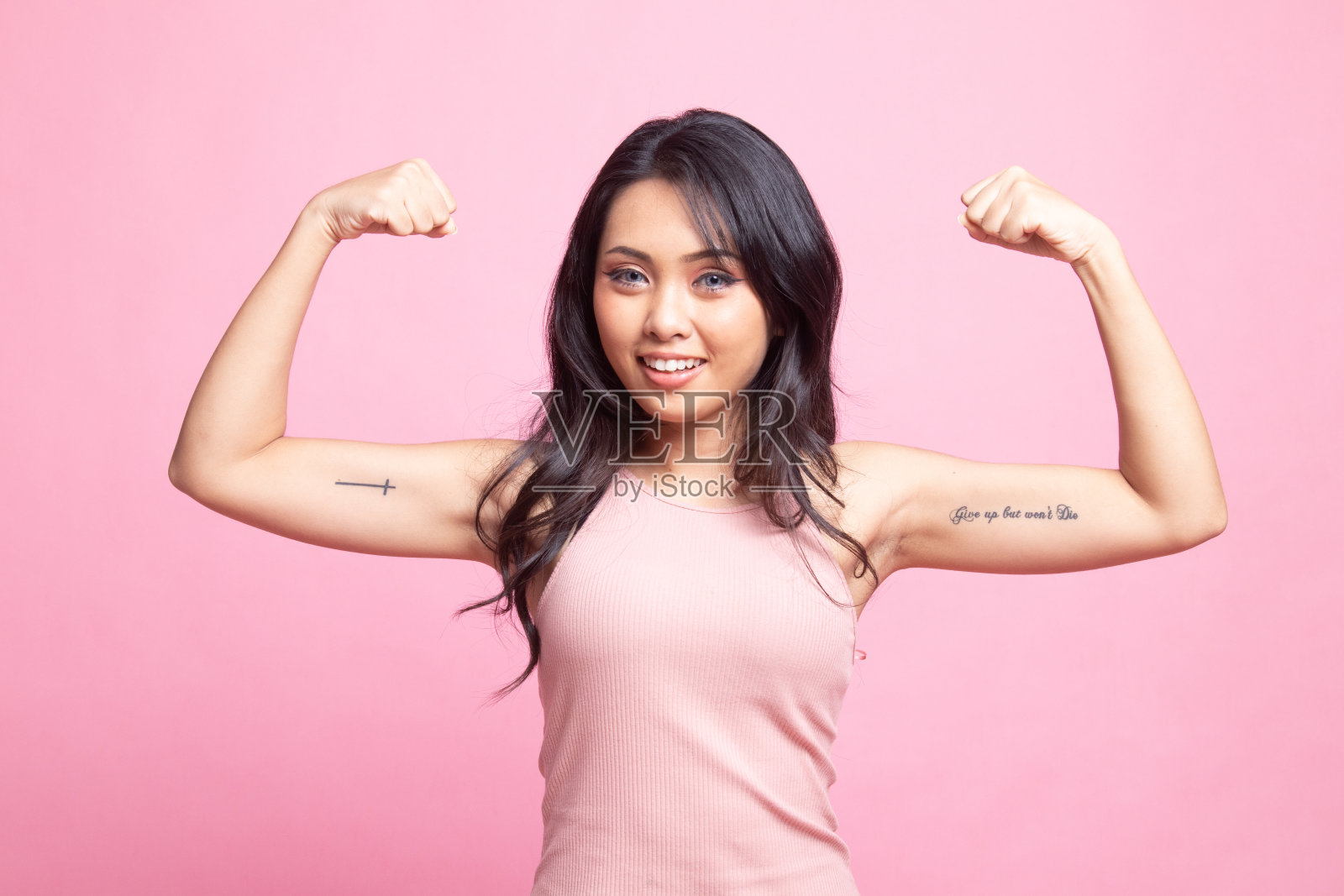 美丽的年轻亚洲女人伸缩二头肌。照片摄影图片