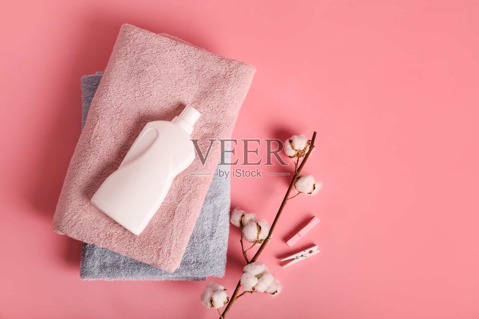 粉色背景上有浴巾和洗涤剂照片摄影图片