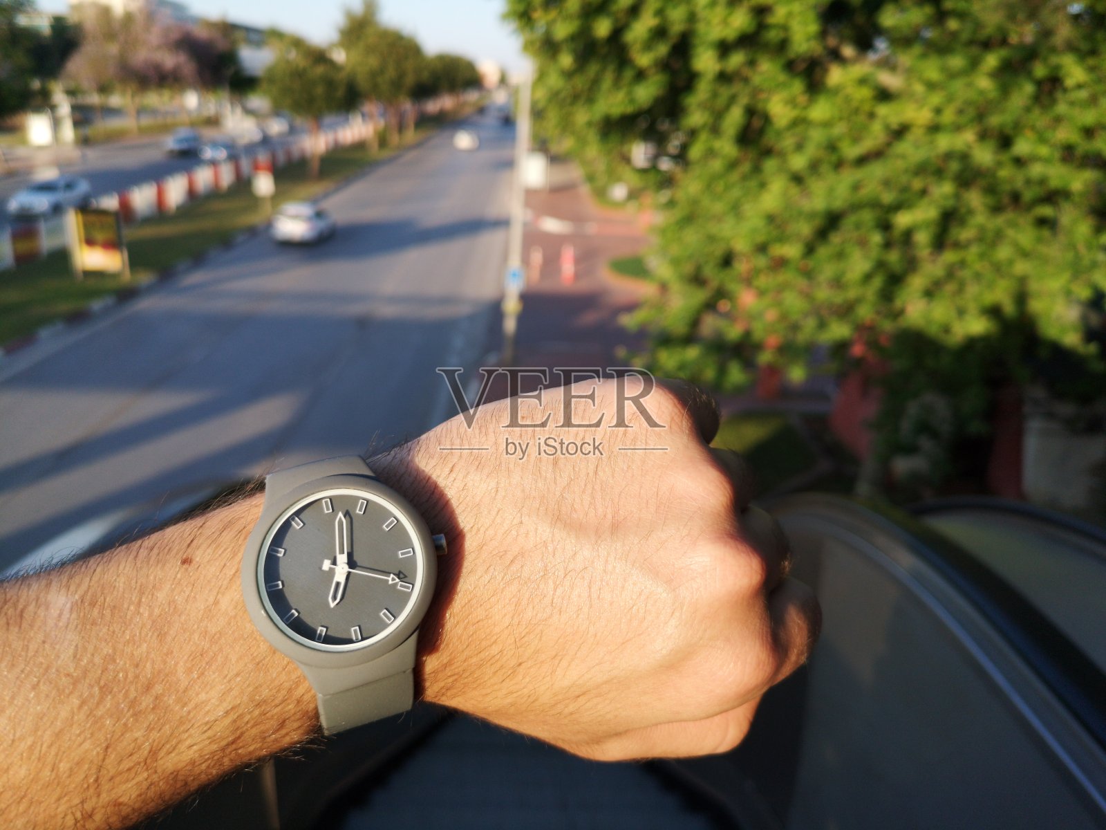 男人看手表就是戴在手上，以查看时间。那个为了上班不迟到而看钟的人。照片摄影图片