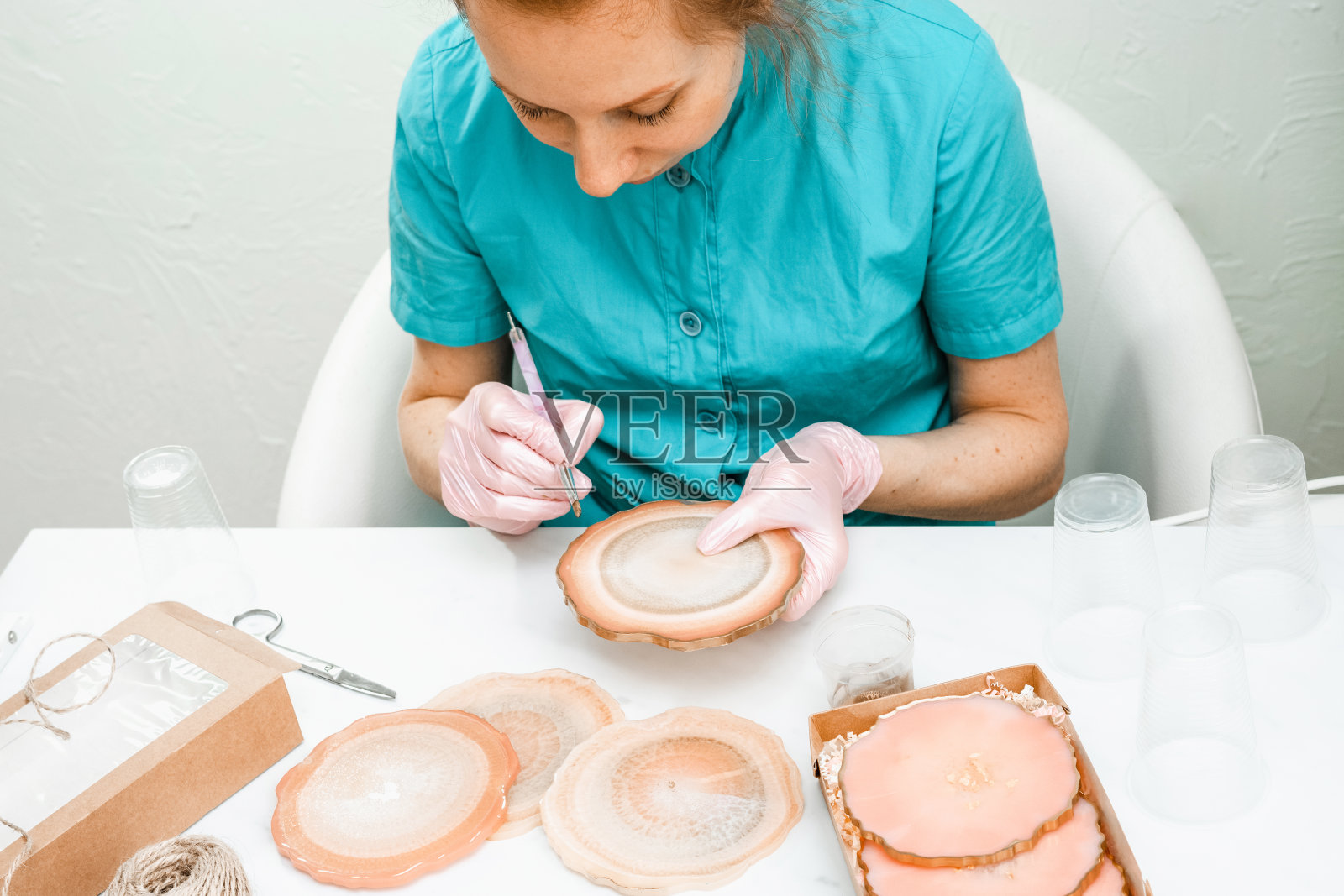 创造力和工艺。一个小女孩用树脂做杯垫。礼品包装。装饰包装。对商业想法。远程工作，在家工作。艺术杯垫。照片摄影图片