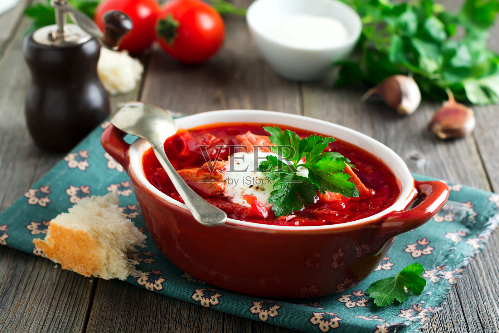 甜菜根汤，肉，酸奶油和欧芹放在一个棕色的陶瓷碗里，旧的木制背景。罗宋汤——乌克兰传统菜肴。有选择性的重点。照片摄影图片