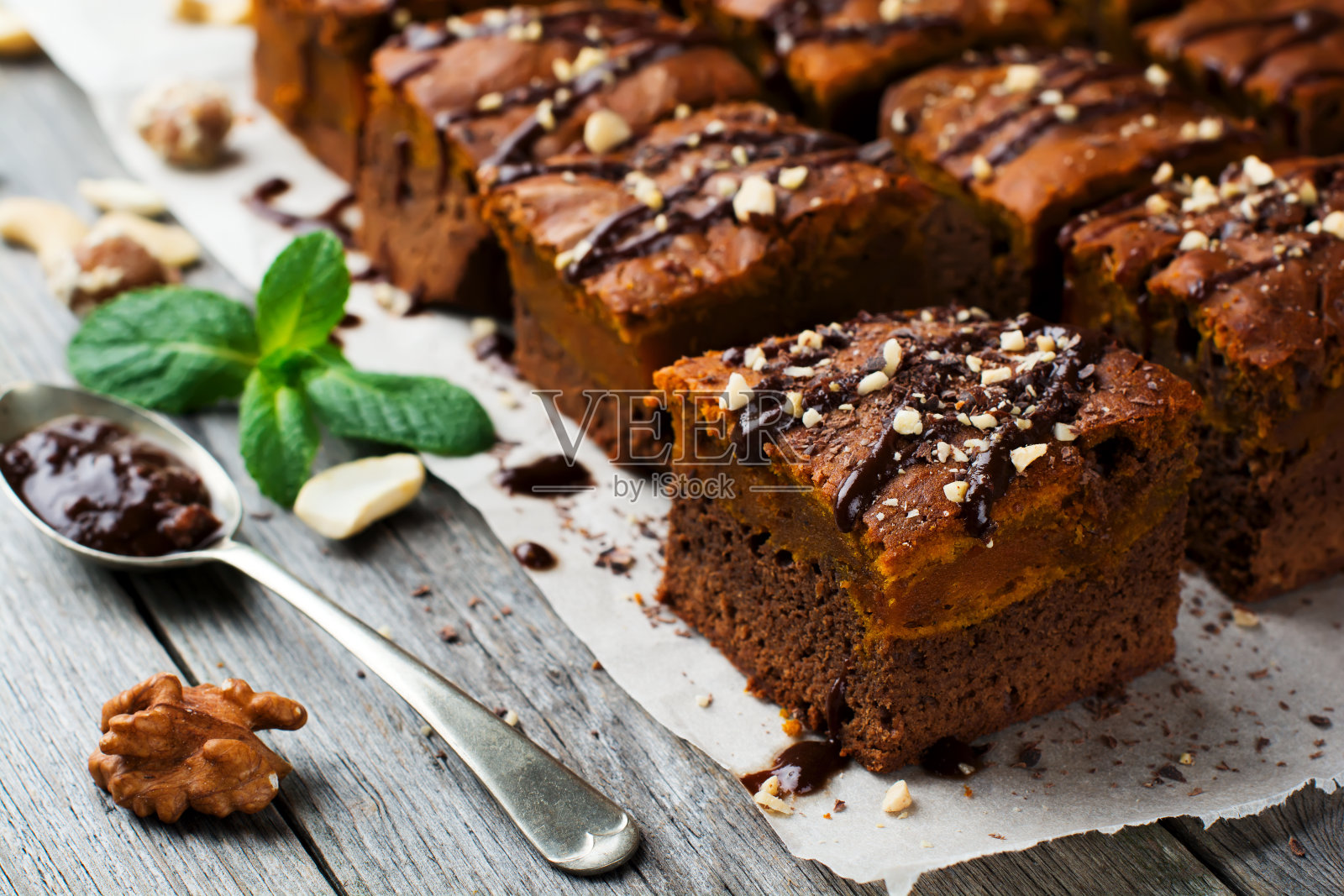 巧克力布朗尼和一个南瓜在一个古老的木制背景。自制方形蛋糕。有选择性的重点。照片摄影图片