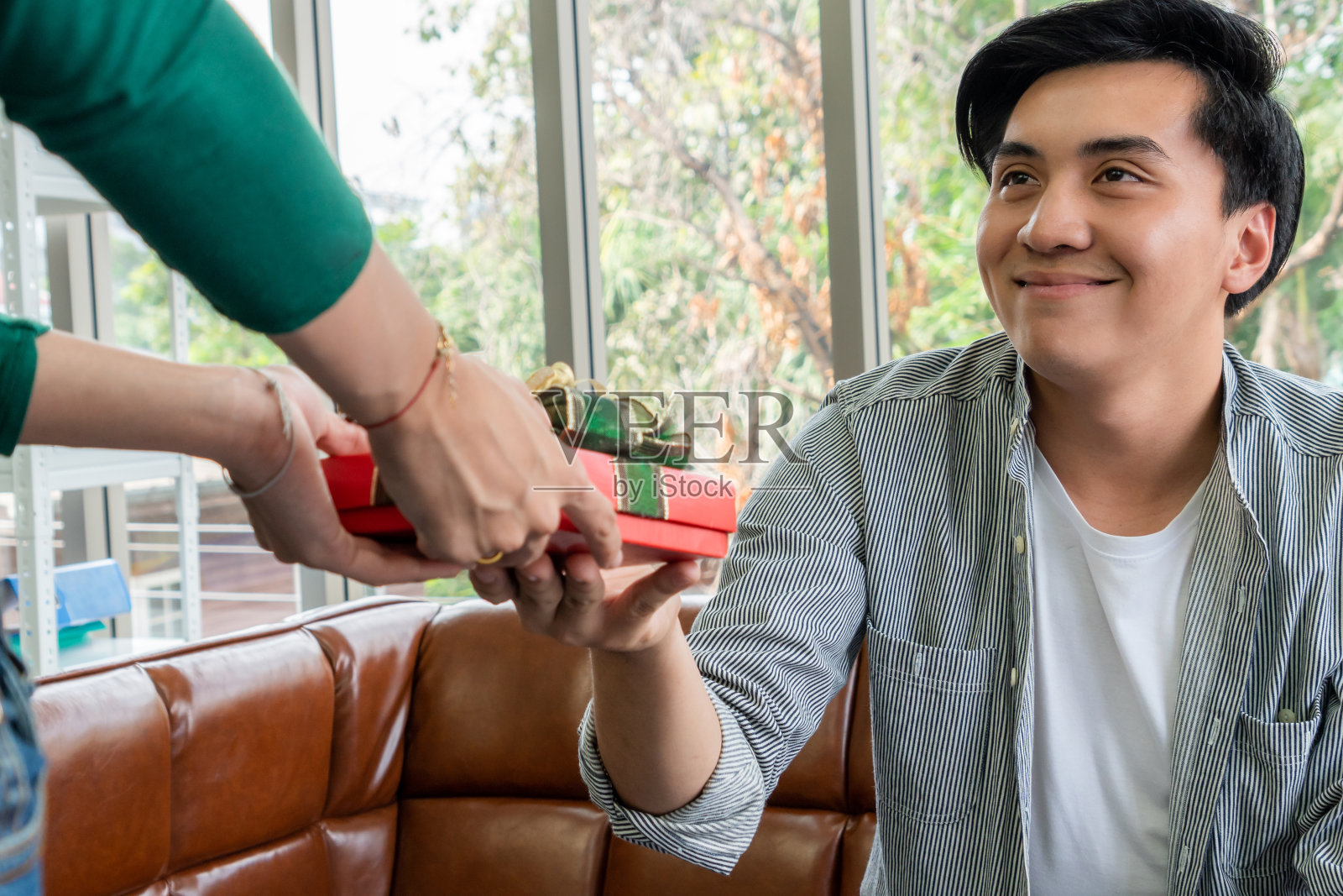 幸福的夫妇送礼物来庆祝结婚纪念日。婚姻生活方式、爱情和关系观念。照片摄影图片