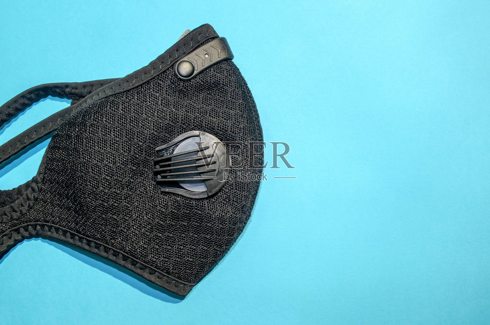 蓝色背景上带过滤器的黑色活性炭防尘口罩照片摄影图片
