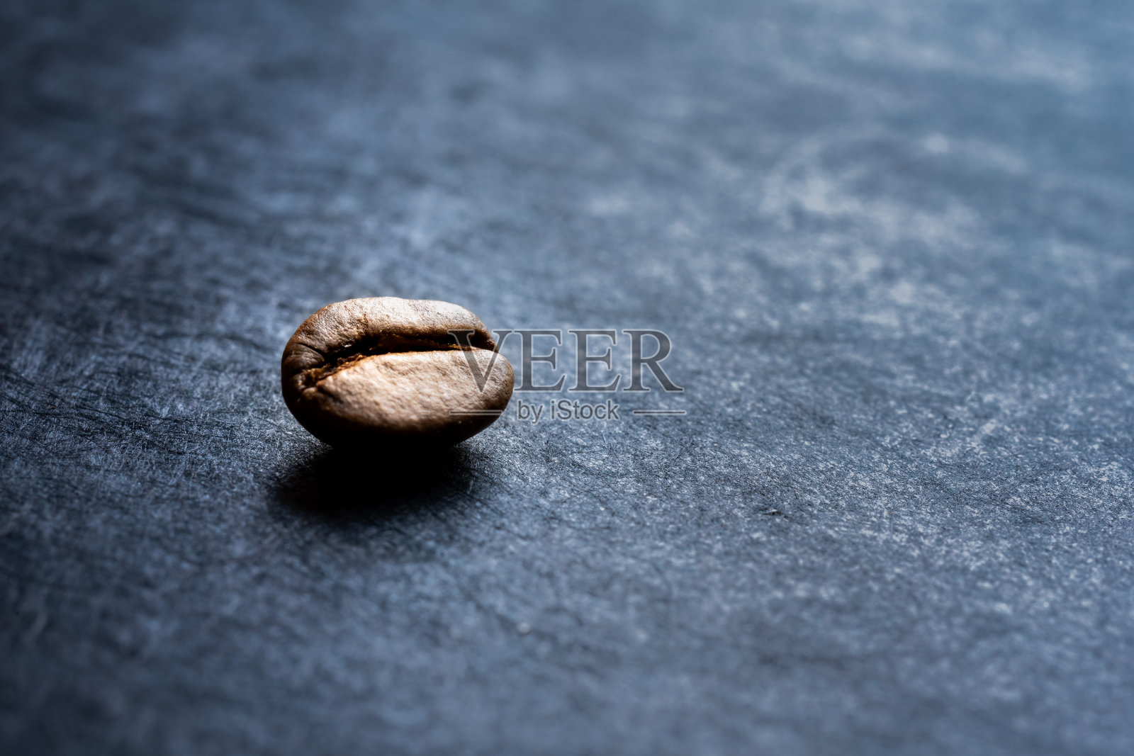 一个孤立的烤咖啡豆在一个黑色的石板背景的特写照片摄影图片