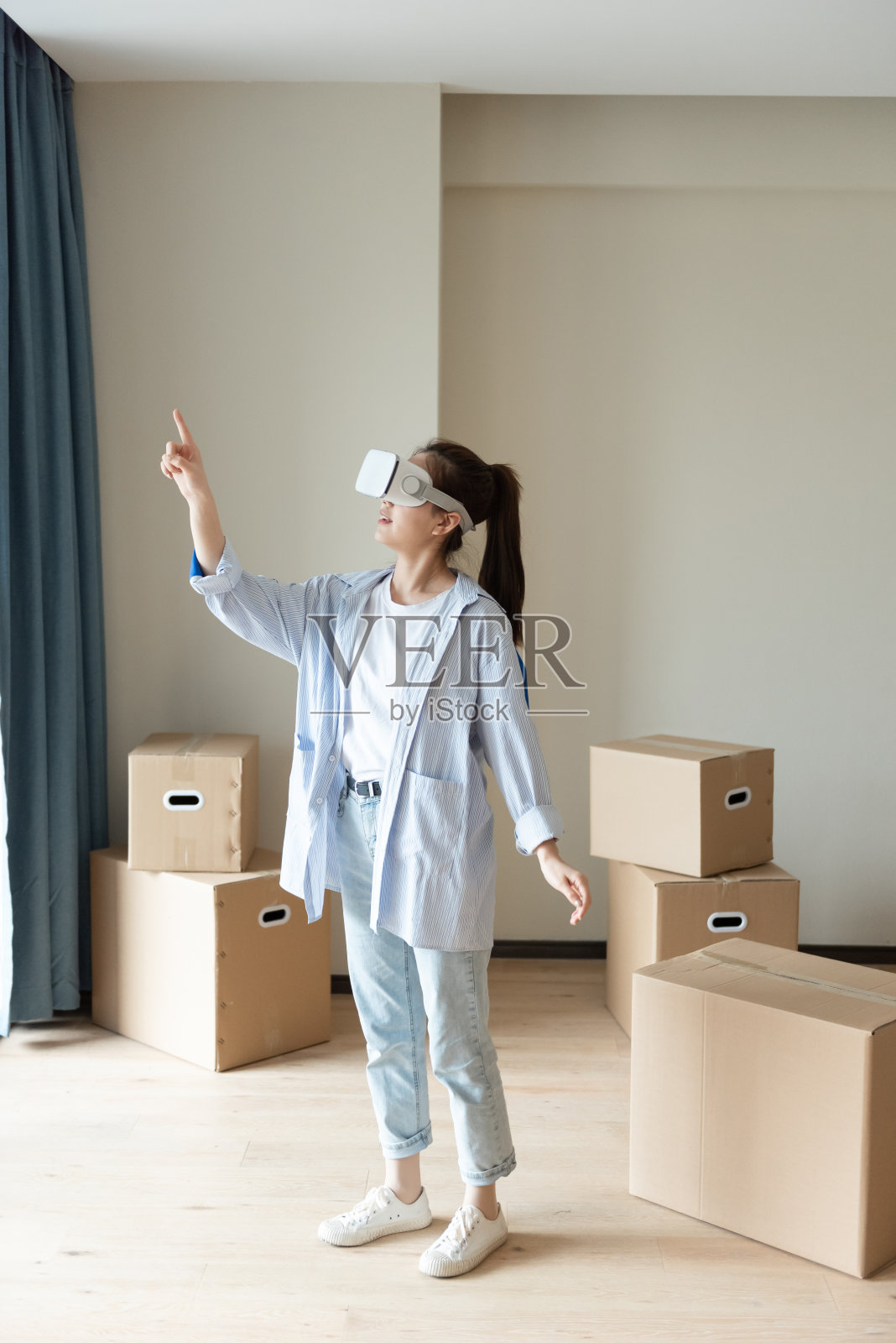 一位年轻的亚洲女性正在使用虚拟现实眼镜照片摄影图片