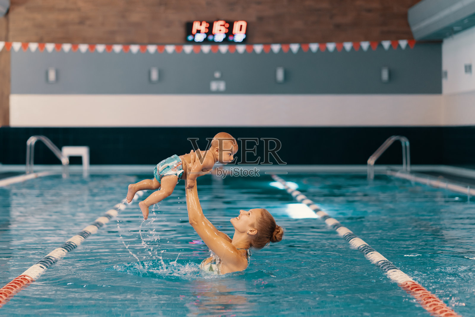 妈妈和小儿子在游泳池里玩得很开心照片摄影图片
