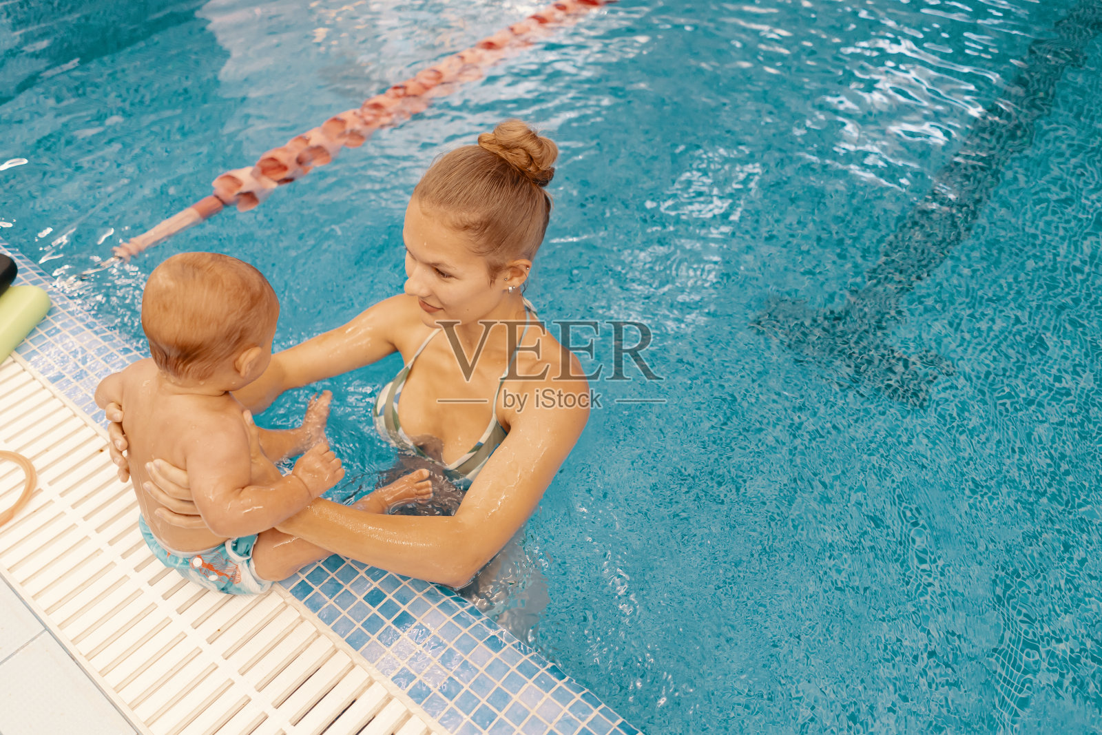 妈妈和小儿子在游泳池里玩得很开心照片摄影图片