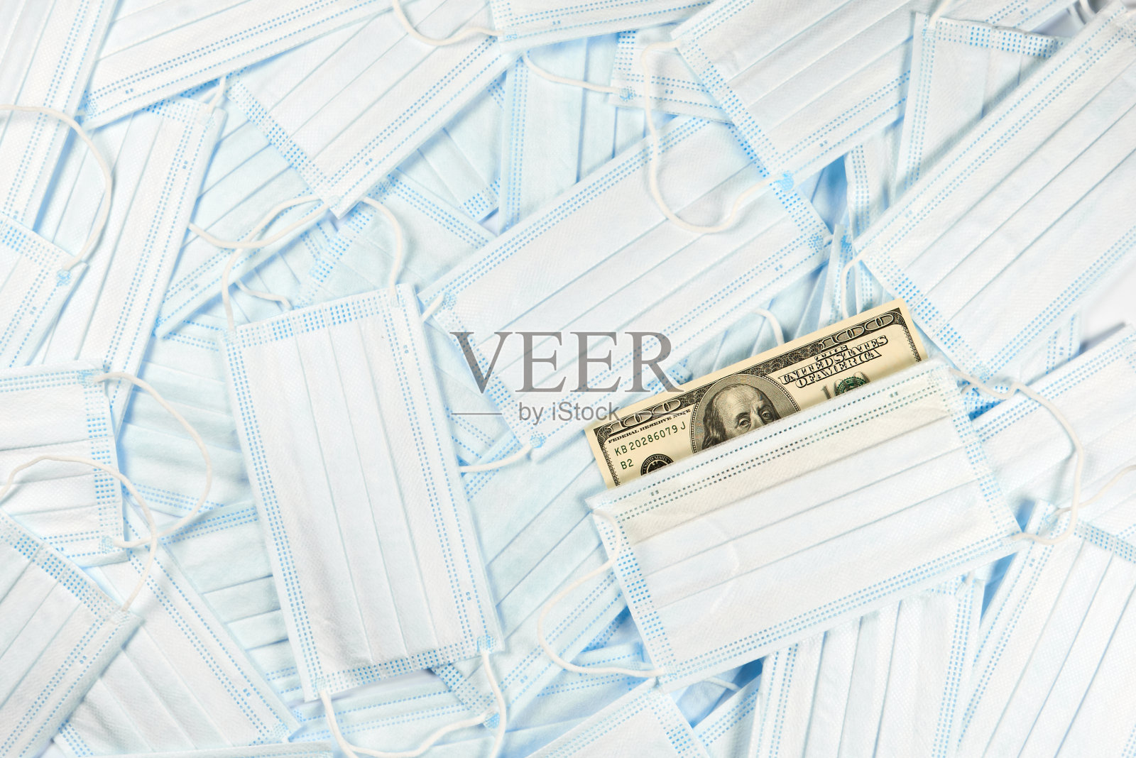 医药、保健和制药概念——许多蓝色一次性医用口罩和百元钞票的背景照片摄影图片