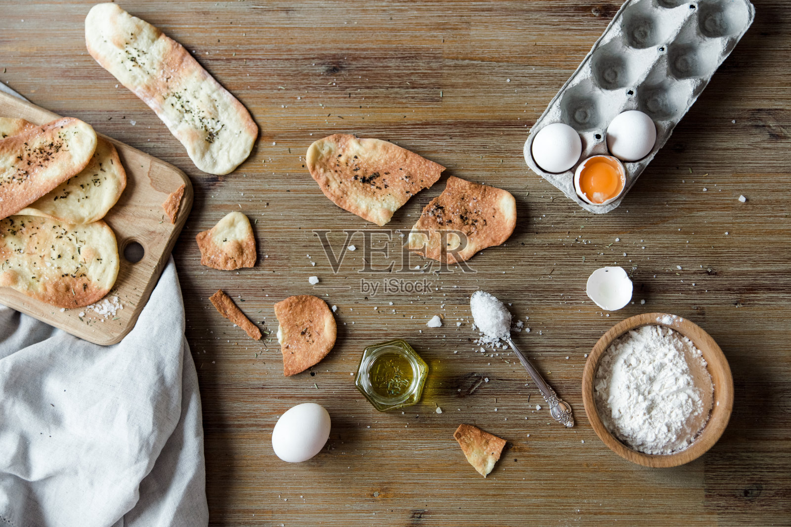 加香料的意大利薄面包。薄玉米饼，传统的意大利佛卡夏面包加上橄榄油和盐。配料的烹饪过程。木制背景照片摄影图片