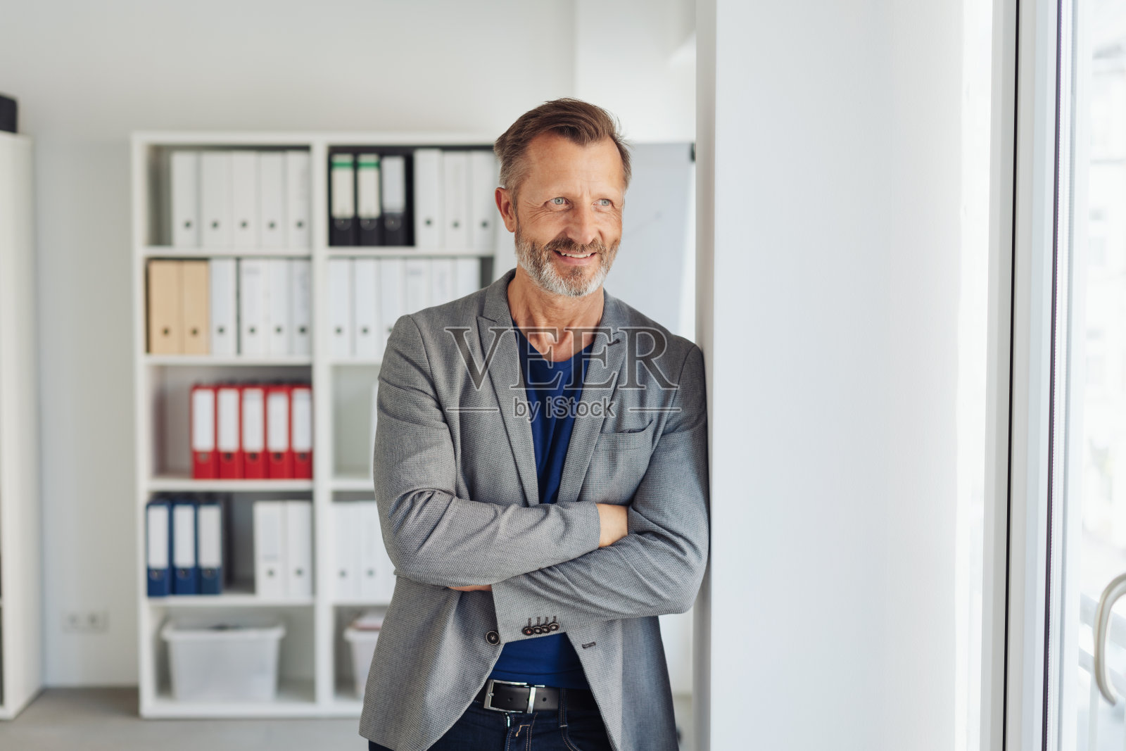 商人站在那里，笑着看着照片摄影图片